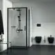 Duschbereich mit schwarzem Duschsystem und Handbrause, Glastür und minimalistischem Design. Zwei schwarze Sanitäranlagen an der Wand, gestaltet von Ideal Standard.